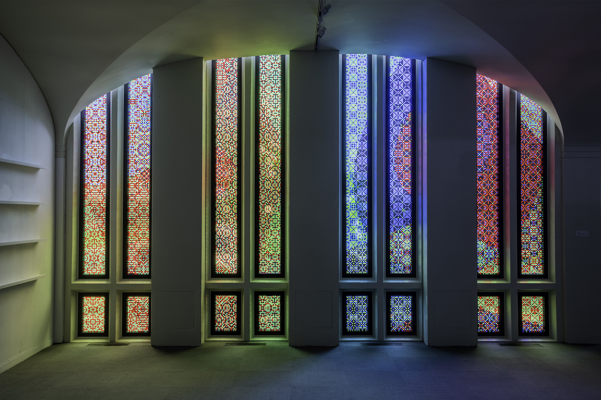 Colorful, glowing, thin, vertical windows contained within an arch.